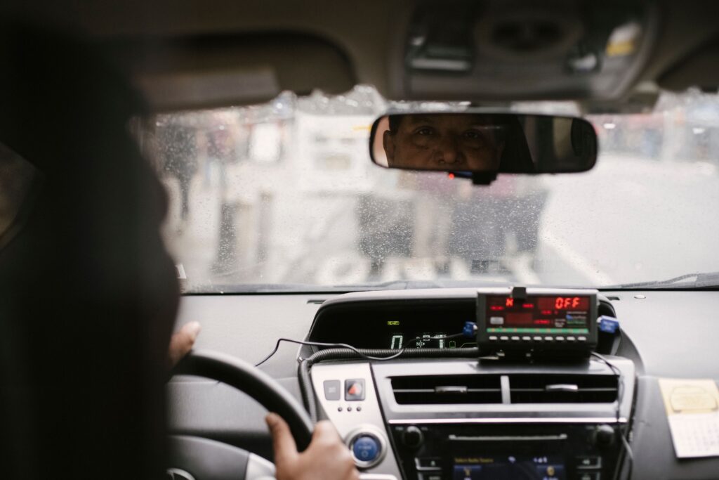 View from inside a taxi showing the driver in the rearview mirror and the taxi meter switched off - yet another potential Thailand Scams where the cab drivers ask for extra money mid-ride or upon reaching destination 