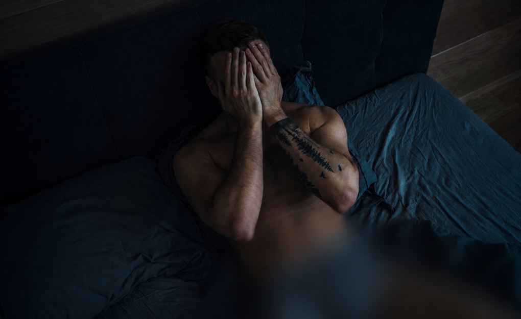 Tourist sitting on a bed after a Bangkok nightlife scam experience in Thailand