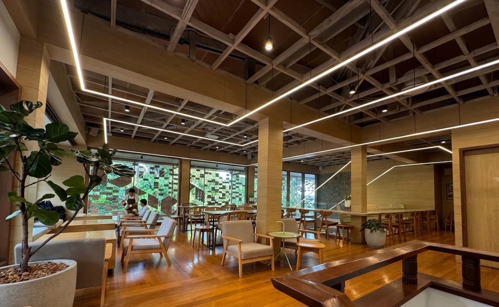 Modern interior of Nana Coffee Roasters in Bangkok featuring minimalist wooden decor, specialty coffee seating area, and trendy cafe ambiance