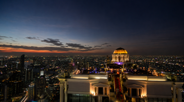 Wide angle evening to night view of Sky Bar at Lebua Bangkok rooftop bar with Bangkok skyline lights, luxury rooftop drinks, slow crowd atmosphere, and panoramic cityscape in Thailand.