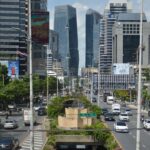 View of modern skyscrapers and heavy traffic in the Bangkok business district, a key consideration when planning your overall Bangkok travel cost
