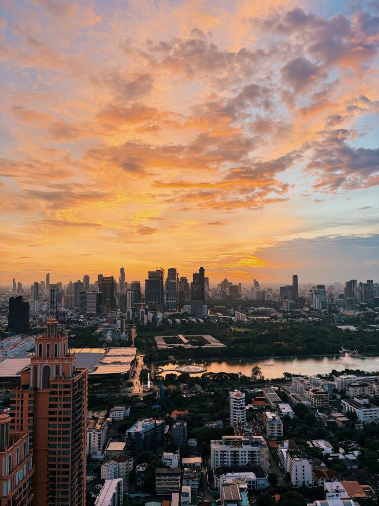 Panoramic sunset view over Bangkok's skyline and urban green spaces, illustrating Thailand's premier health and wellness tourism hub.